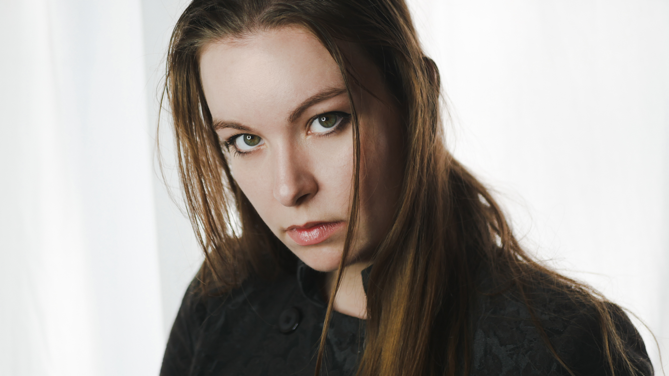 Portrait of singer Sofia Schmidt wearing a black jacket in front of a white background.
