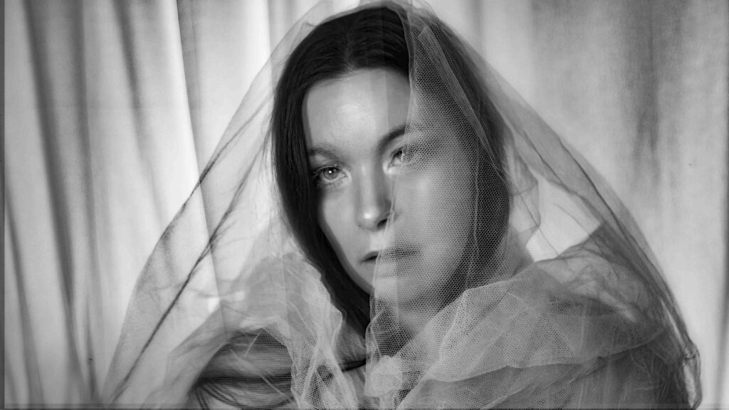 Performer Sofia Schmidt in a white veil. Press photo for her act The Lady In The Shroud. Self Portrait 2026